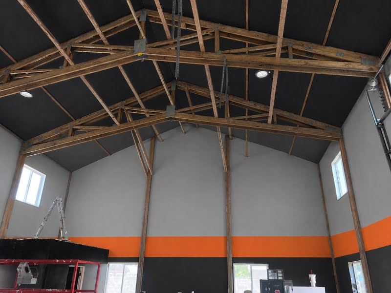 Barn interior repaint with exposed truss ceiling